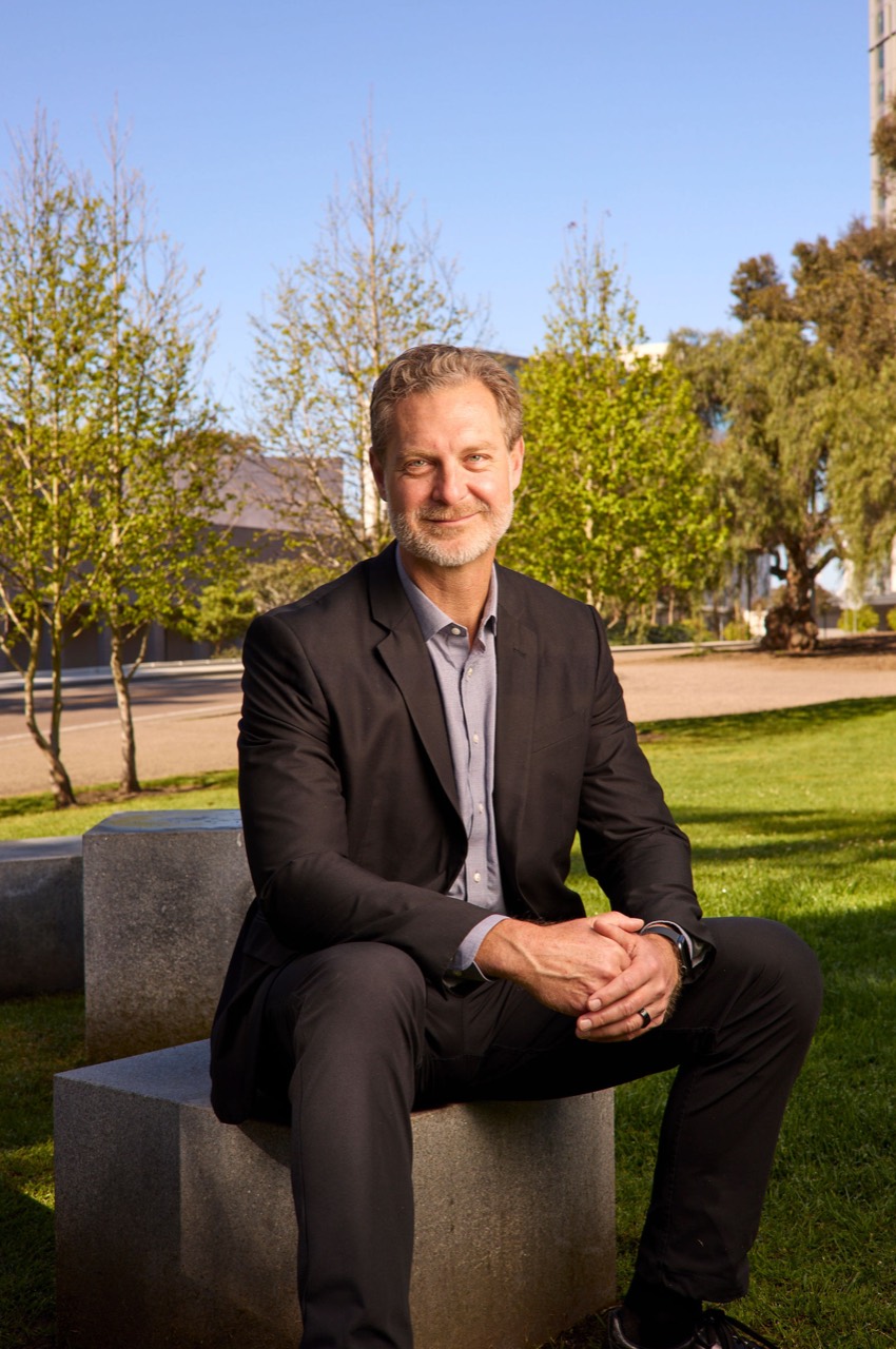 Brett Pollak seated outdoors on the UC San Diego campus